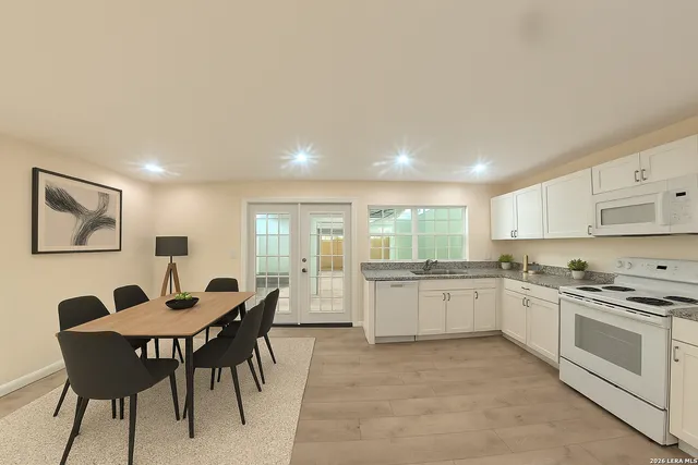 a kitchen with a stove a sink a dining table and chairs