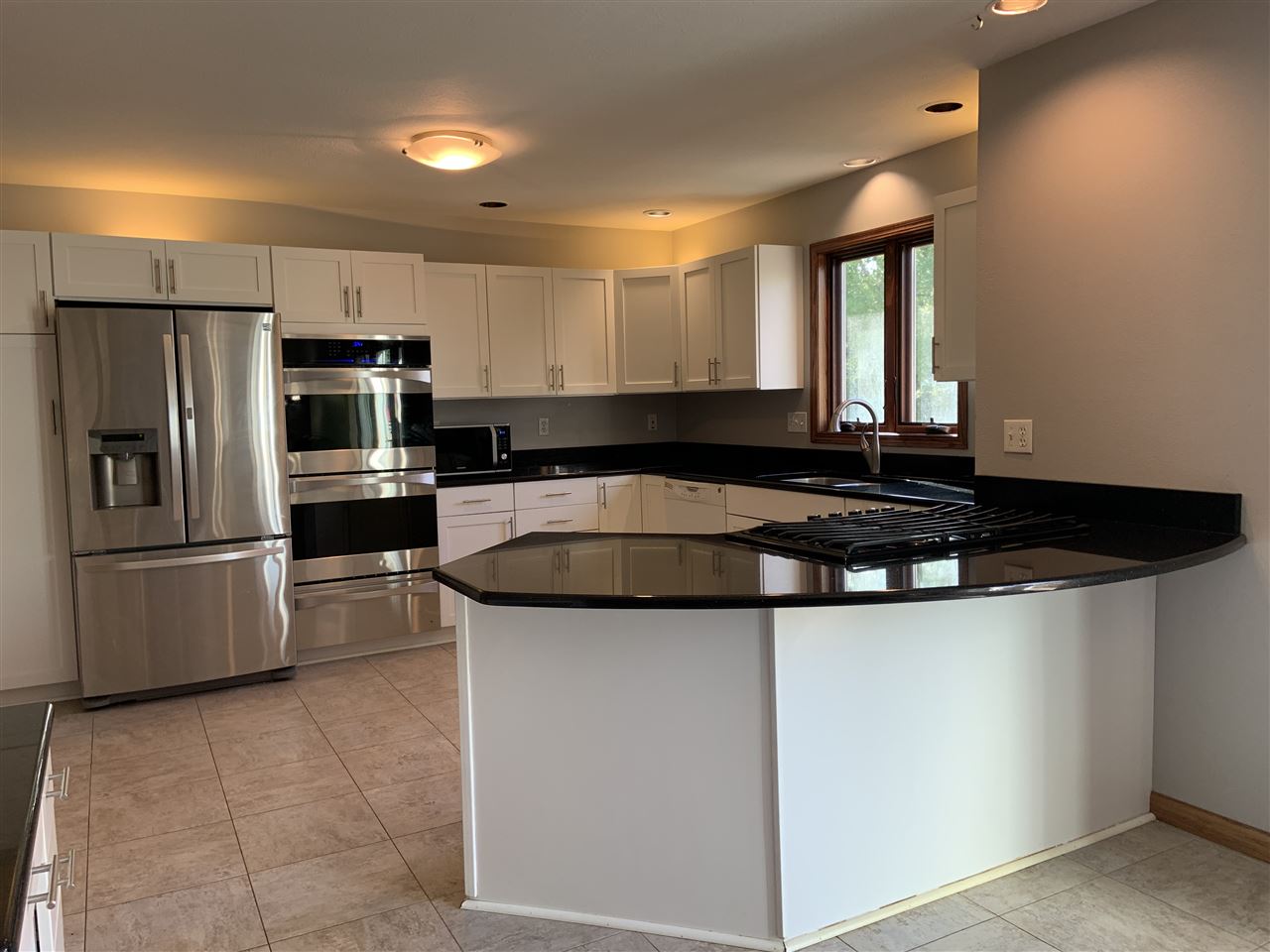 6912 Sentinel Road Rockford, IL 61107 - Photo 12 of 27 a kitchen with kitchen island a counter top space a sink and stainless steel appliances