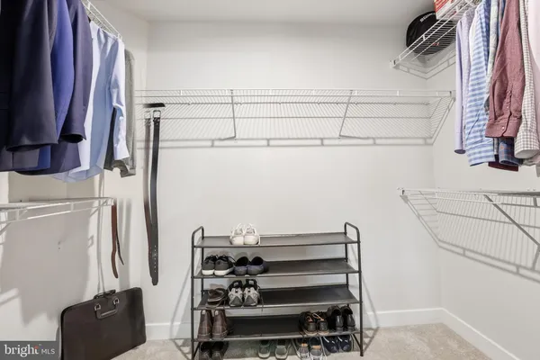 a view of walk in closet with clothes and shoes