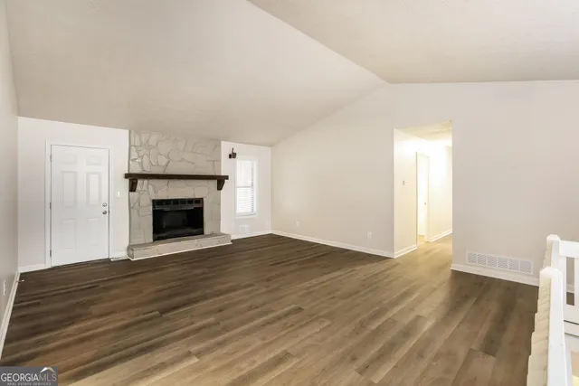 a view of empty room with wooden floor and fireplace