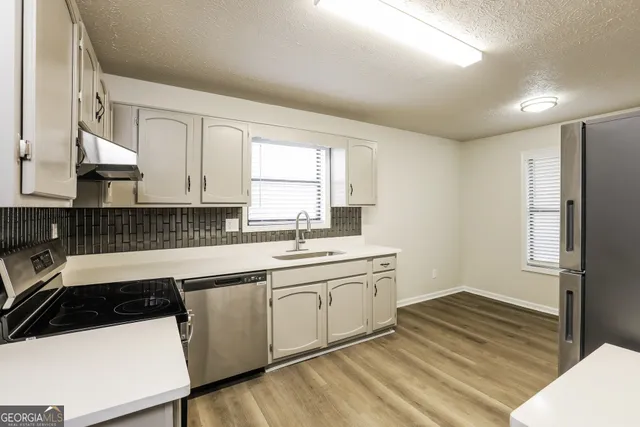 a kitchen with a sink a stove and refrigerator