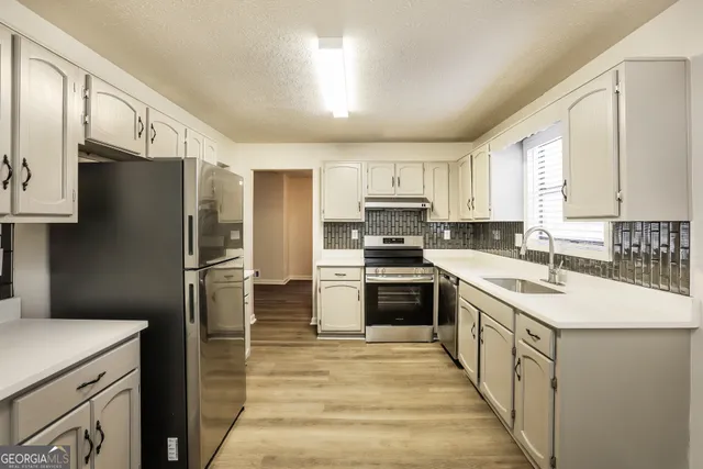 a kitchen with kitchen island granite countertop a sink appliances cabinets and counter space