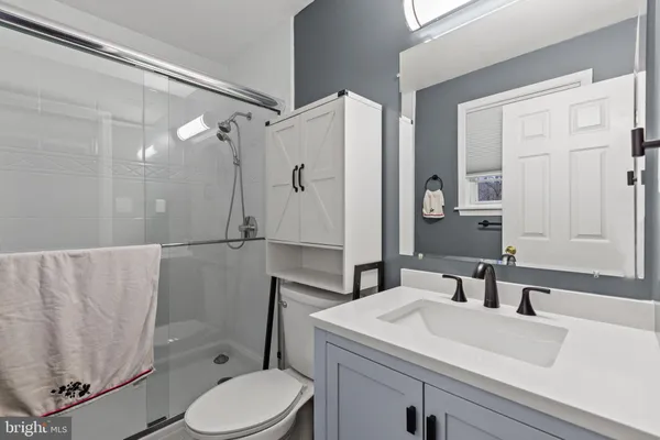 a bathroom with a sink toilet vanity and shower