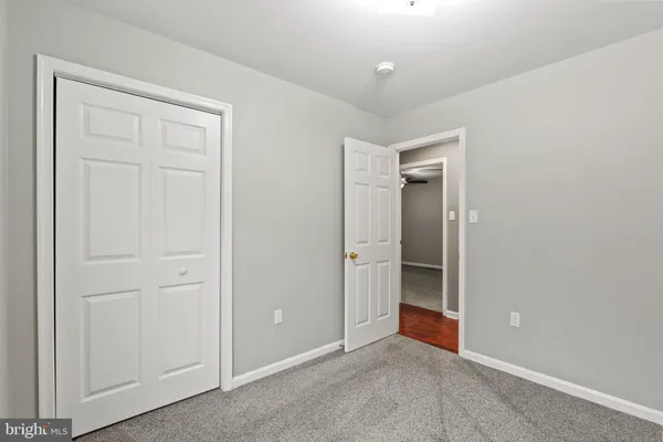 an empty room with closet and a bathroom sink