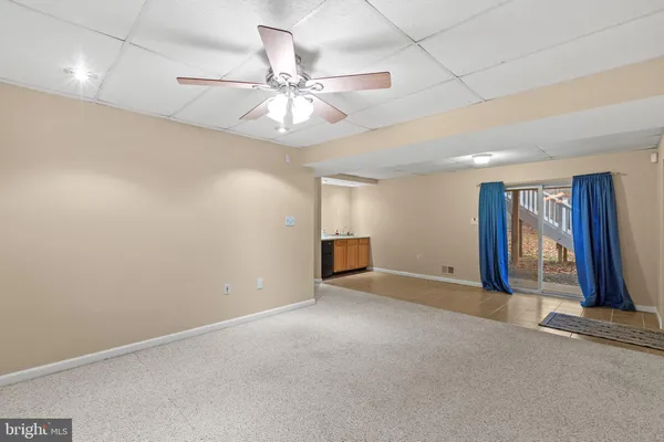 an empty room with fan and windows