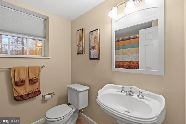 a bathroom with a toilet a sink and mirror