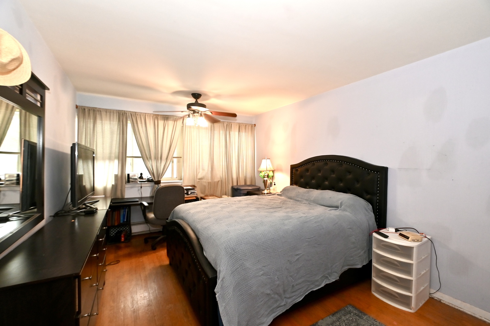 200 Ridge Avenue, Unit 1E Evanston, IL 60202 - Photo 8 of 13 a bedroom with a bed and a flat tv screen on dresser