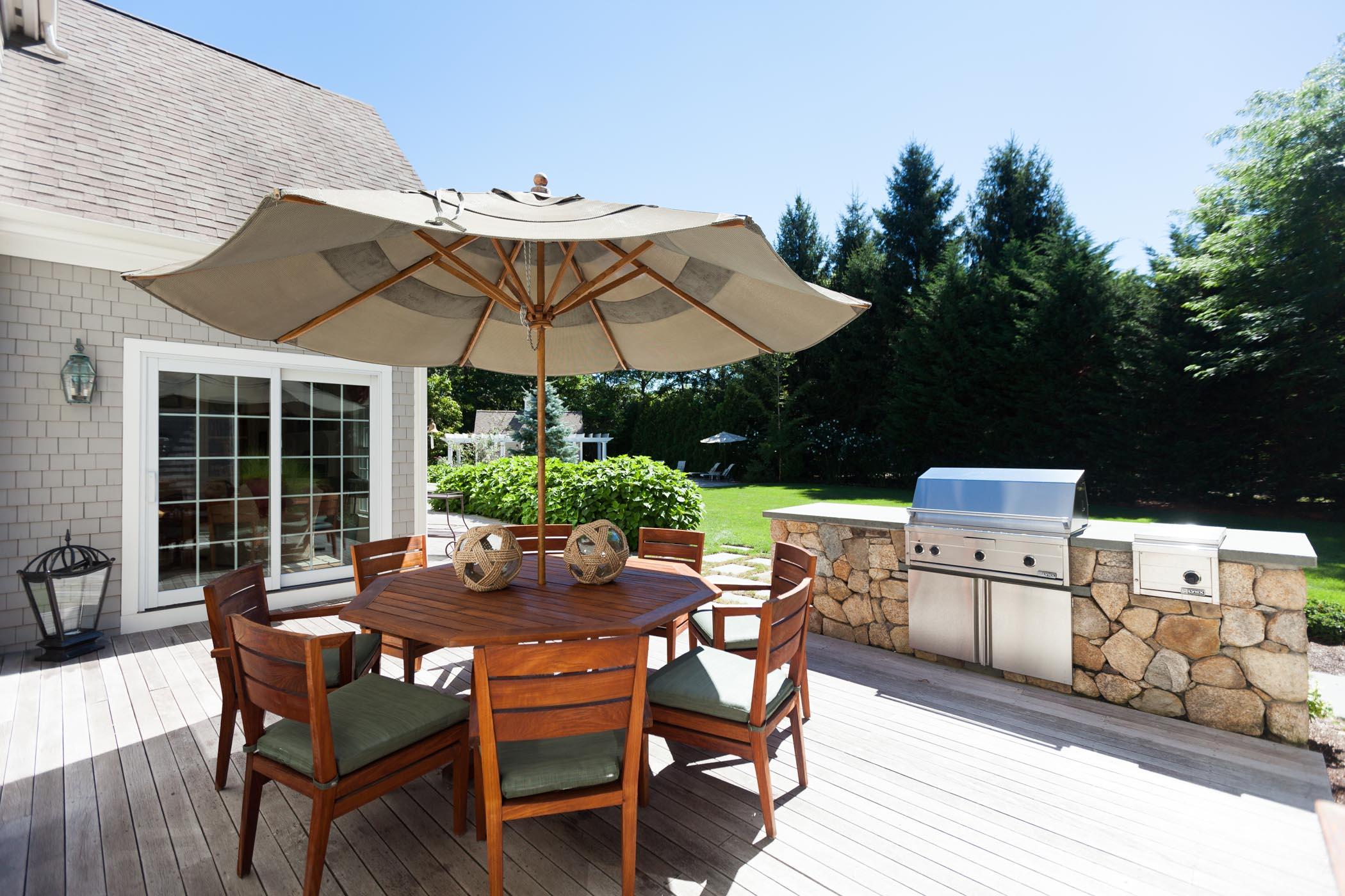 91 Great Bay Road Osterville, MA 02655 - Photo 20 of 27 a patio with a table and chairs under an umbrella