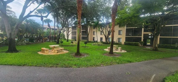 a view of a house with backyard and trees