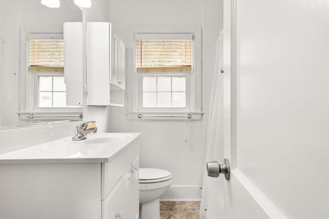 a bathroom with a sink a toilet and a window