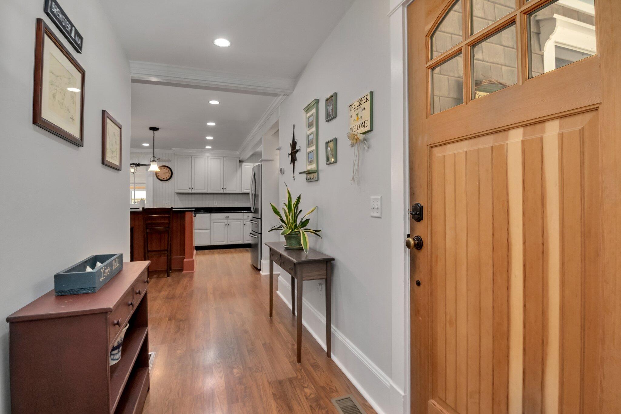 730 Slough Road Brewster, MA 02631 - Photo 12 of 87 a view of a hallway with wooden floor and a potted plant