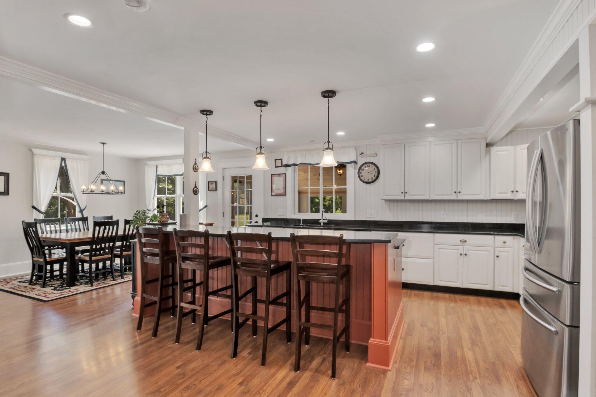 730 Slough Road Brewster, MA 02631 - Photo 15 of 87 a kitchen with stainless steel appliances kitchen island granite countertop a table chairs stove and white cabinets