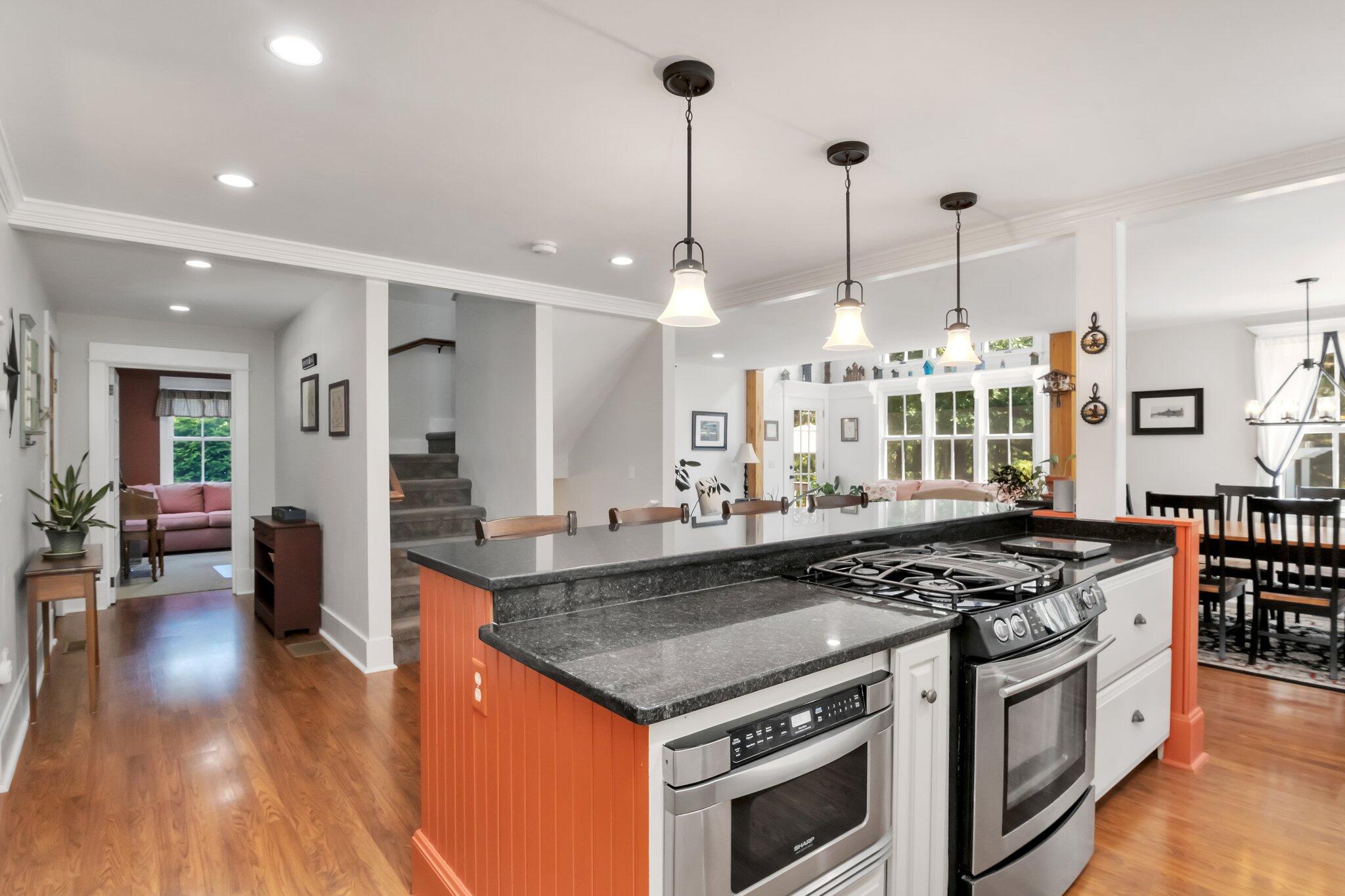 730 Slough Road Brewster, MA 02631 - Photo 23 of 87 a kitchen with stainless steel appliances granite countertop a stove a chimney a sink and a wooden floors