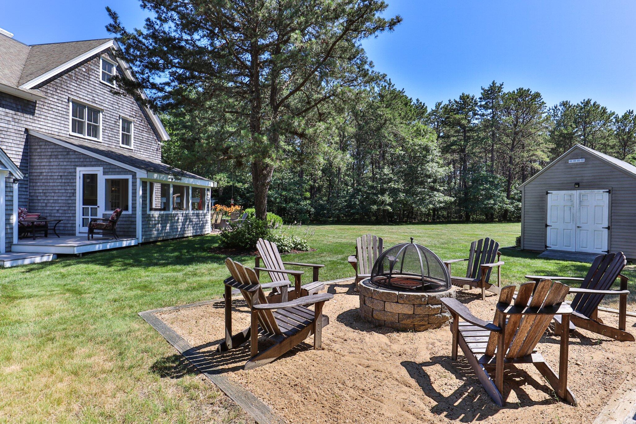 730 Slough Road Brewster, MA 02631 - Photo 64 of 87 a view of a patio with table and chairs and potted plants with wooden floor and fence