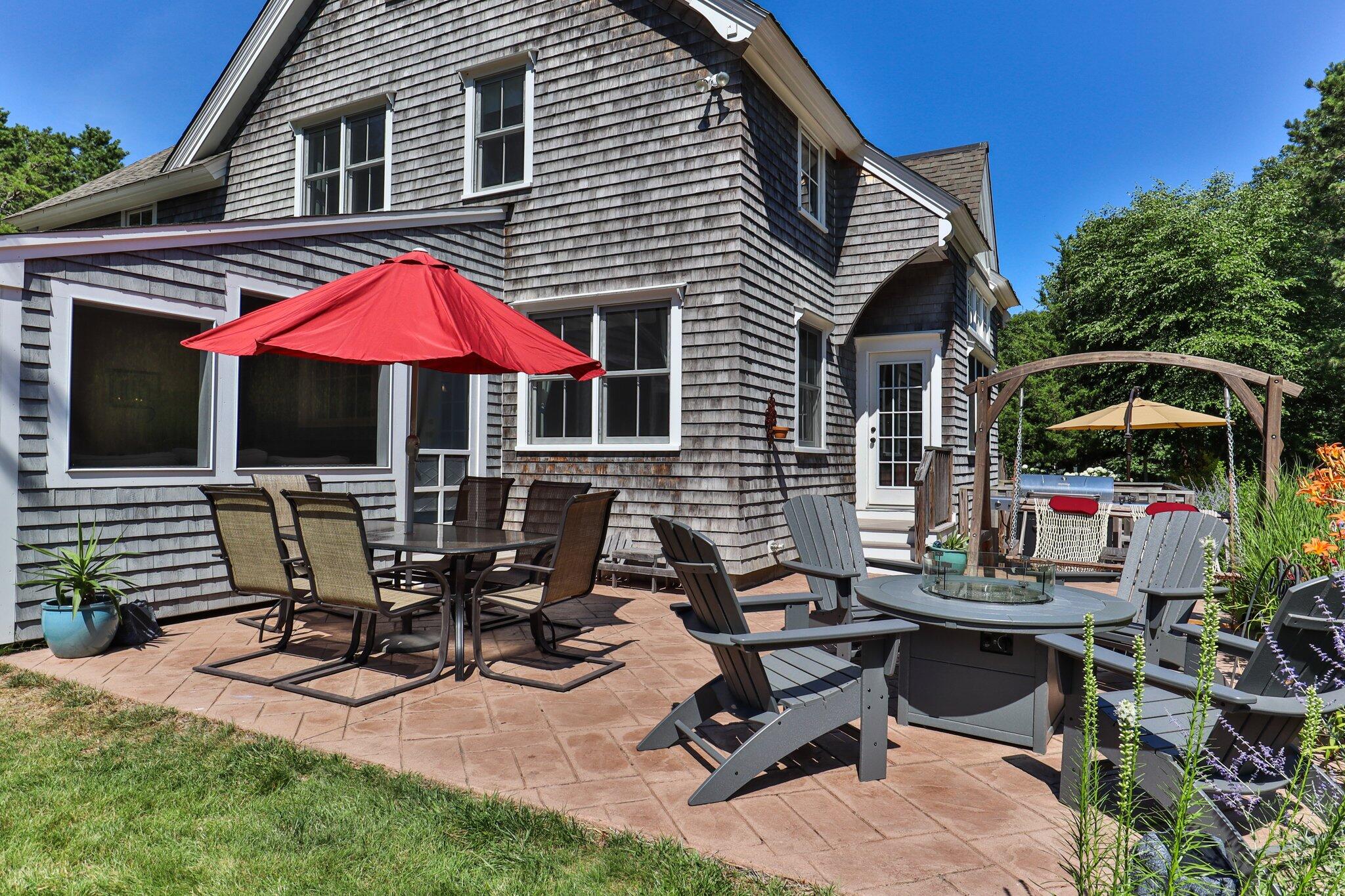 730 Slough Road Brewster, MA 02631 - Photo 70 of 87 a view of a patio with table and chairs under an umbrella