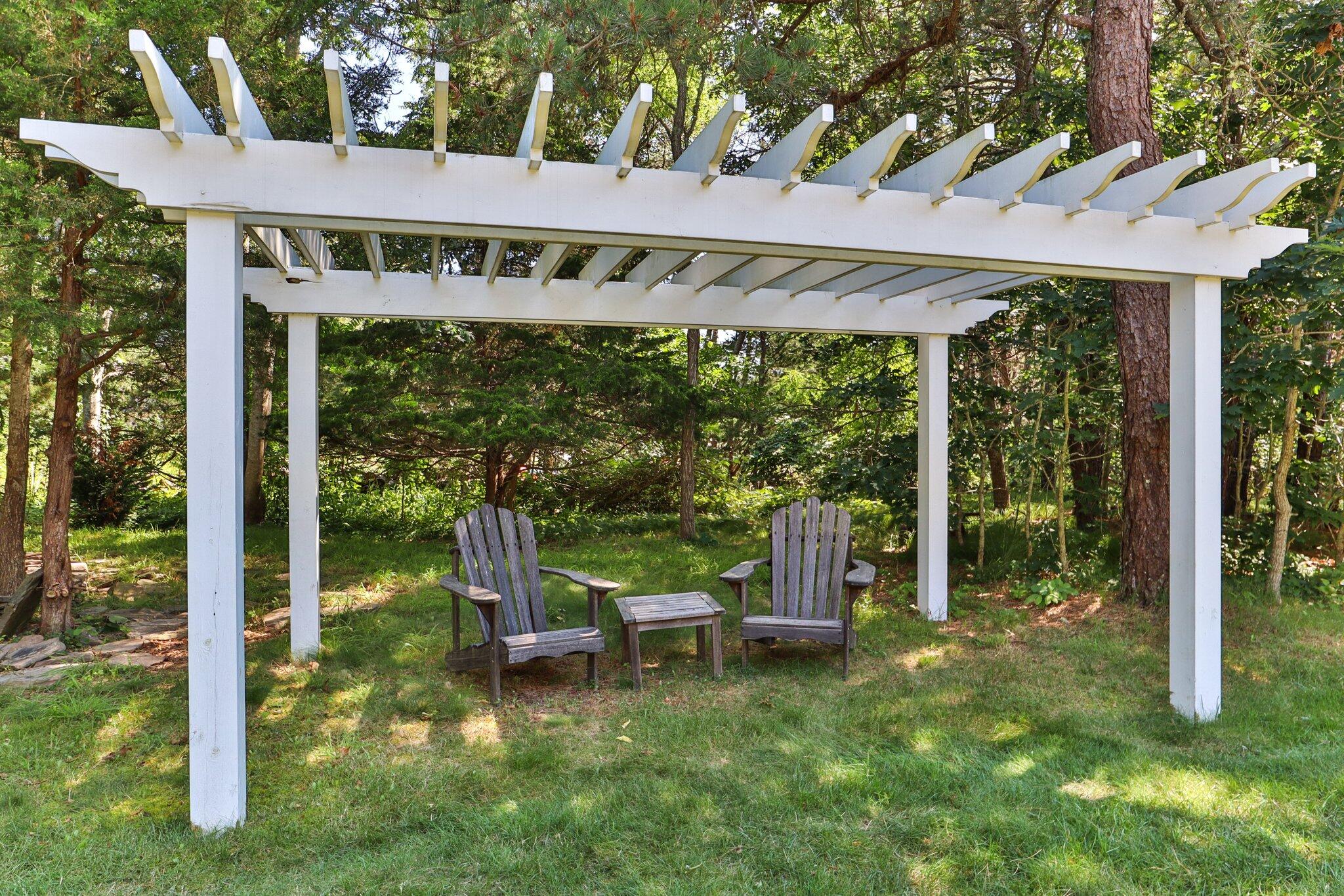 730 Slough Road Brewster, MA 02631 - Photo 76 of 87 a view of a patio with a table chairs and a backyard