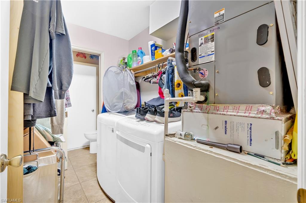 1867 17th Street Southwest Naples, FL 34117 - Photo 22 of 31 Laundry area featuring heating unit, light tile patterned flooring, and washer and clothes dryer