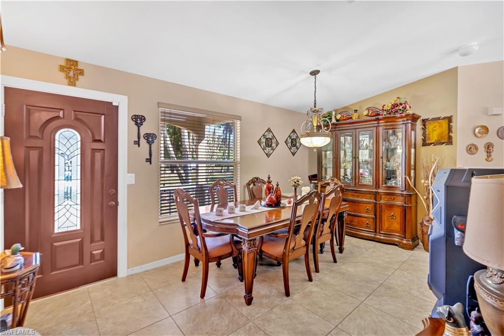1867 17th Street Southwest Naples, FL 34117 - Photo 7 of 31 Dining area with light tile patterned floors and vaulted ceiling