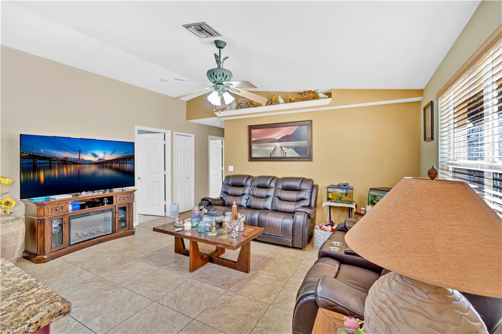 1867 17th Street Southwest Naples, FL 34117 - Photo 10 of 31 Living area with vaulted ceiling, a ceiling fan, and light tile patterned flooring