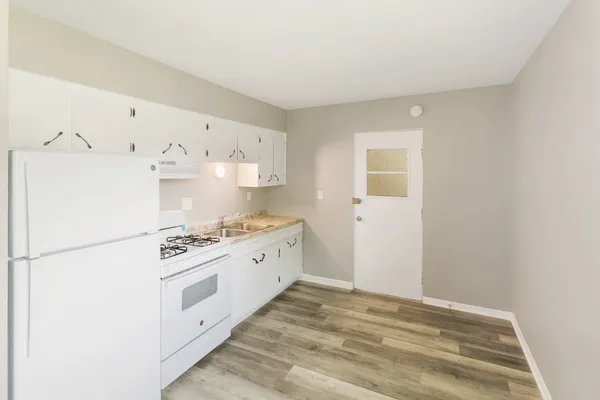 a kitchen with granite countertop white cabinets and white appliances