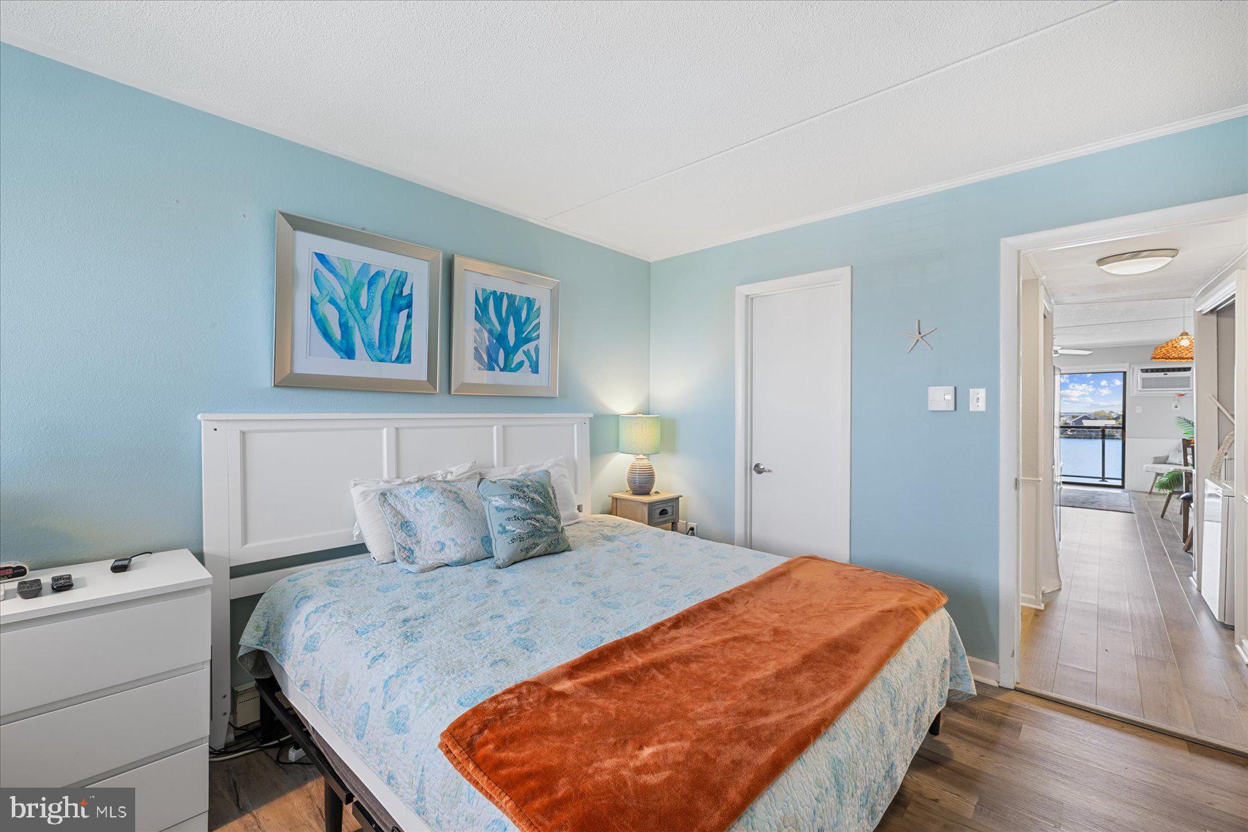 169 Jamestown Road, Unit 503 Ocean City, MD 21842 - Photo 8 of 18 a bedroom with a bed and wooden floor