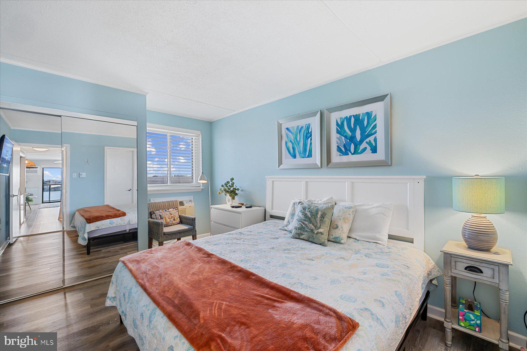 169 Jamestown Road, Unit 503 Ocean City, MD 21842 - Photo 9 of 18 a bedroom with a bed and wooden floor