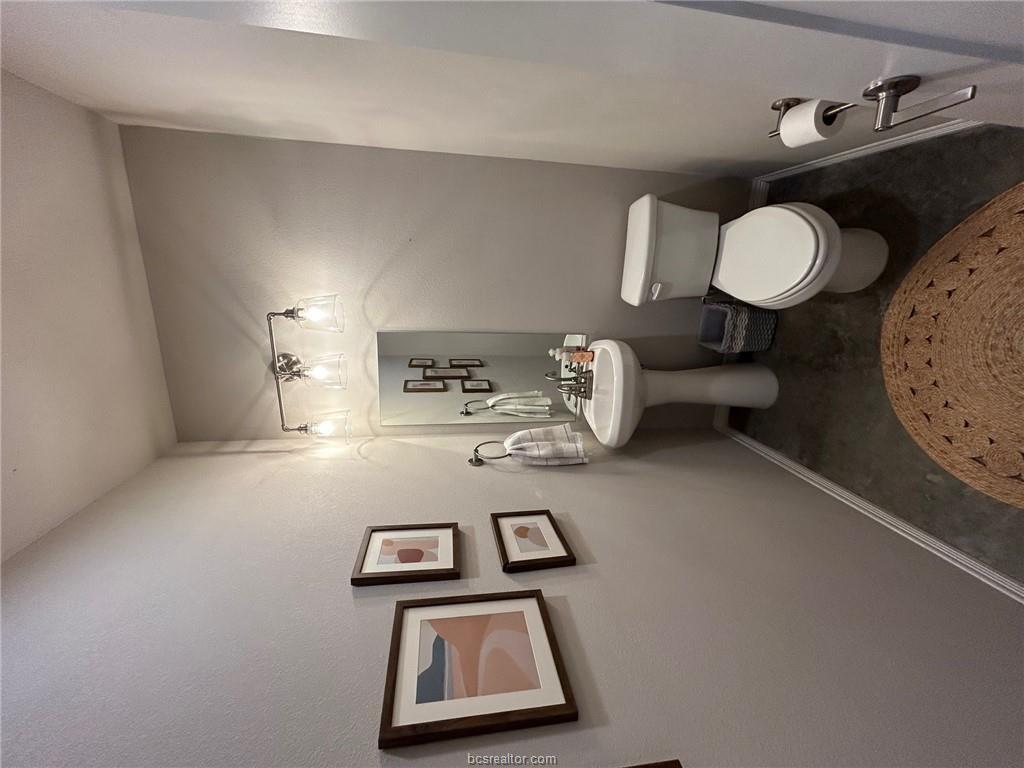 3102 Green Street Bryan, TX 77801 - Photo 21 of 26 a bathroom with a toilet sink and mirror