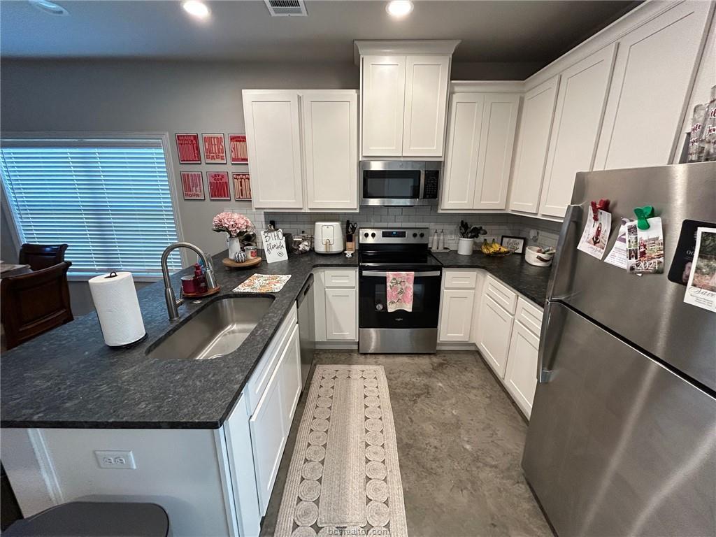 3102 Green Street Bryan, TX 77801 - Photo 6 of 26 a kitchen with granite countertop stainless steel appliances a sink a stove top oven a counter space and cabinets