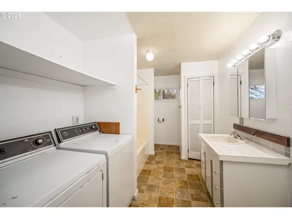 a bathroom with a sink a toilet a mirror and shower