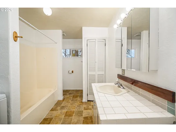 a bathroom with a sink mirror and a shower