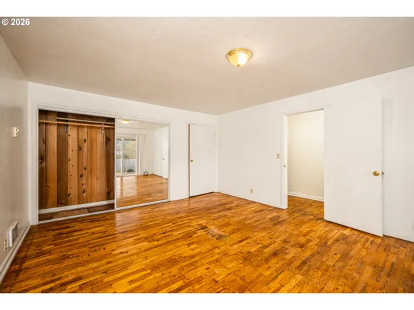 a view of an empty room with wooden floor