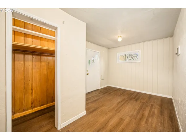 a view of empty room with wooden floor