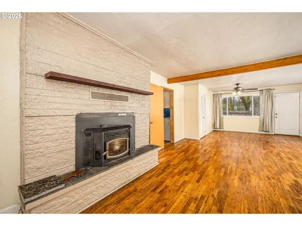 a view of empty room with wooden floor and fireplace
