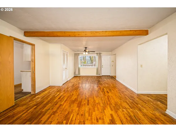 a view of empty room with wooden floor