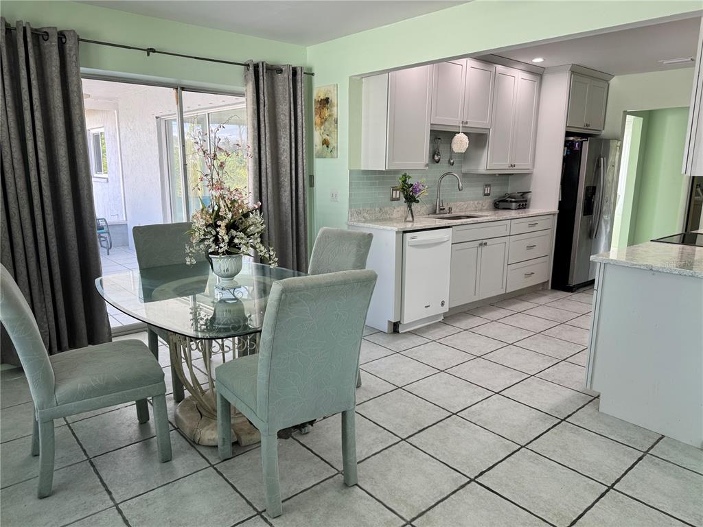 1048 Porpoise Road Venice, FL 34293 - Photo 5 of 26 a kitchen with a dining table chairs and refrigerator