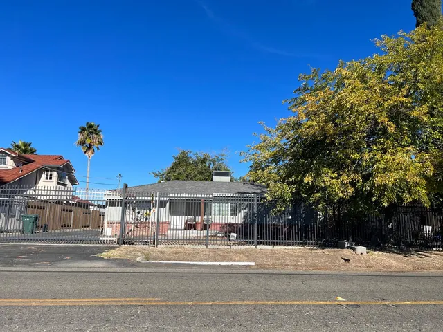 a view of a trees and pathway in front of the house