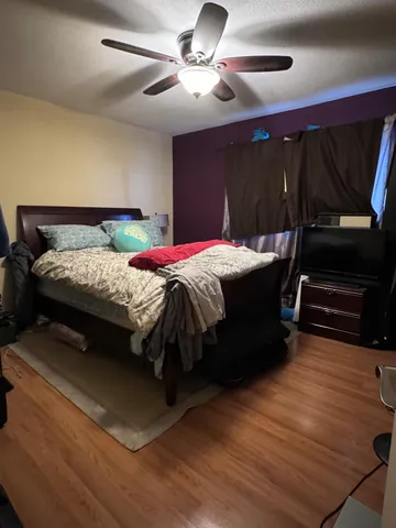 a bedroom with a bed and a ceiling fan