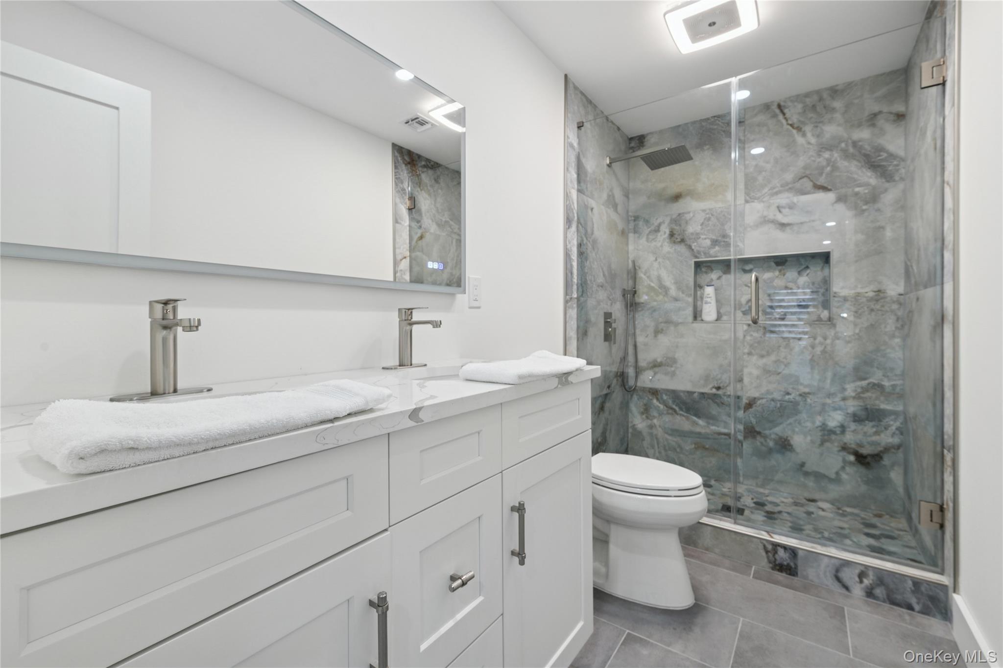 10 Sagamore Road Hampton Bays, NY 11946 - Photo 16 of 41 a bathroom with a double vanity sink toilet and shower