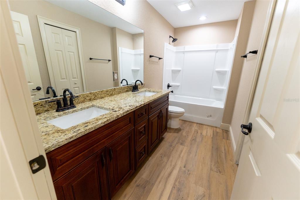 8342 Southwest 125th Ct Road Dunnellon, FL 34432 - Photo 48 of 65 a bathroom with a granite countertop sink a mirror and a shower