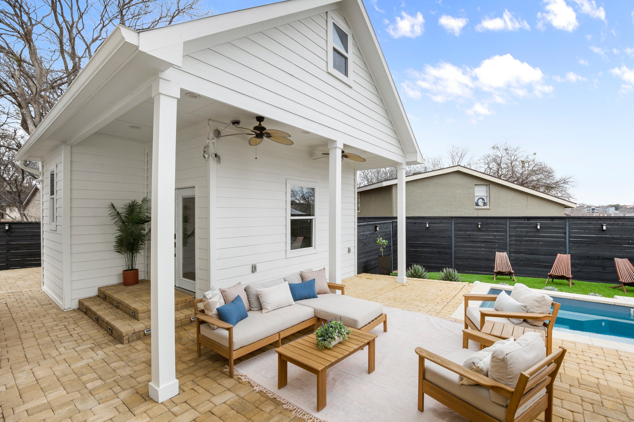 1813 Crooked Lane Austin, TX 78741 - Photo 28 of 39 a view of a patio with couches and a table and chairs with wooden floor and fence