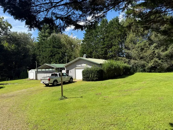 a white house with a big yard and large trees