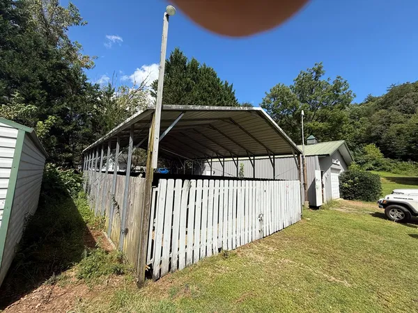 a view of a house with backyard and trees