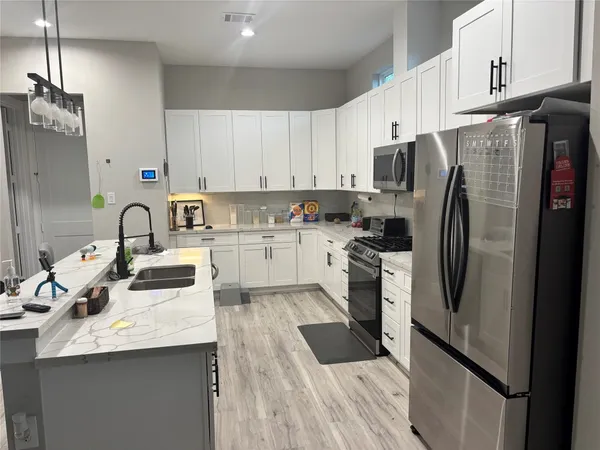 a kitchen with stainless steel appliances granite countertop a refrigerator sink and stove