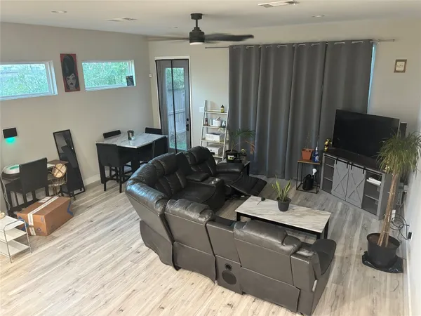 a living room with furniture a flat screen tv and gym equipment