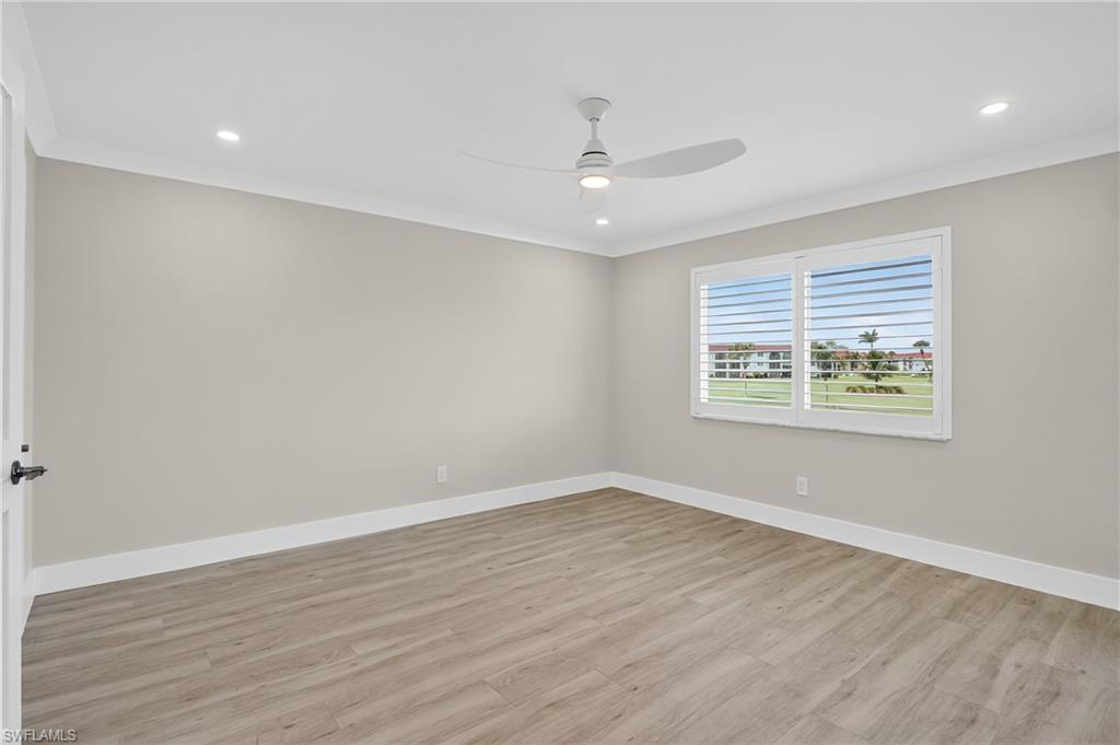 29 High Point Circle East, Unit 204 Naples, FL 34103 - Photo 12 of 29 an empty room with wooden floor and windows