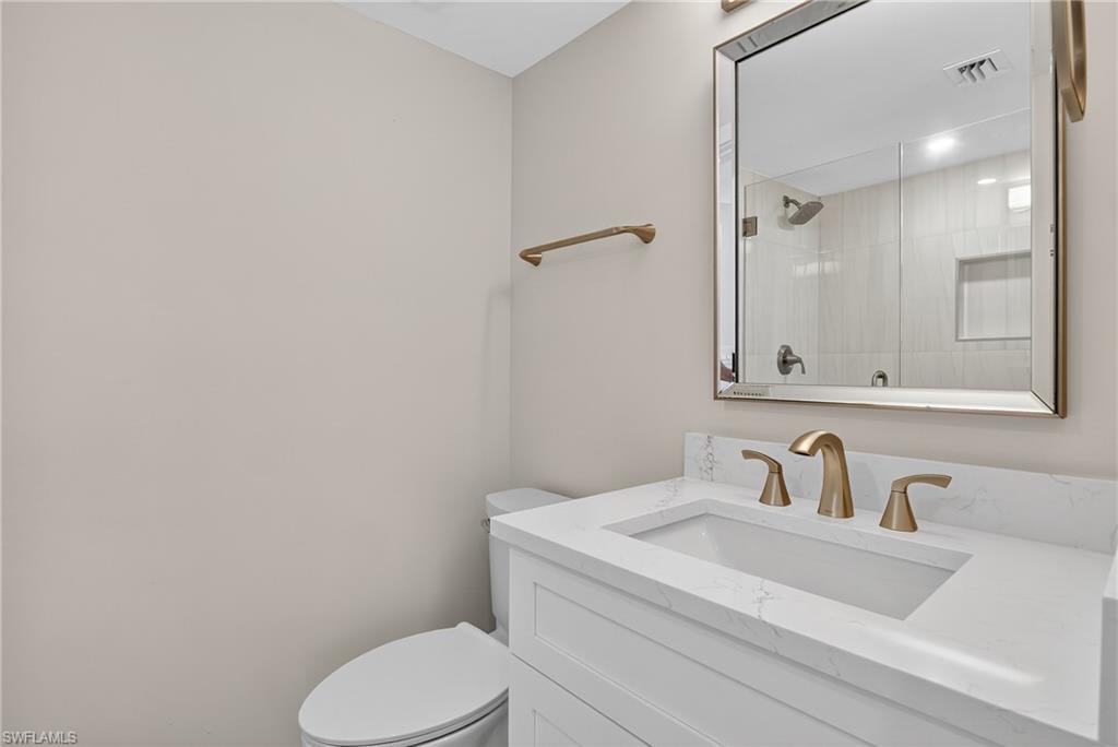 29 High Point Circle East, Unit 204 Naples, FL 34103 - Photo 14 of 29 a bathroom with a sink toilet and mirror