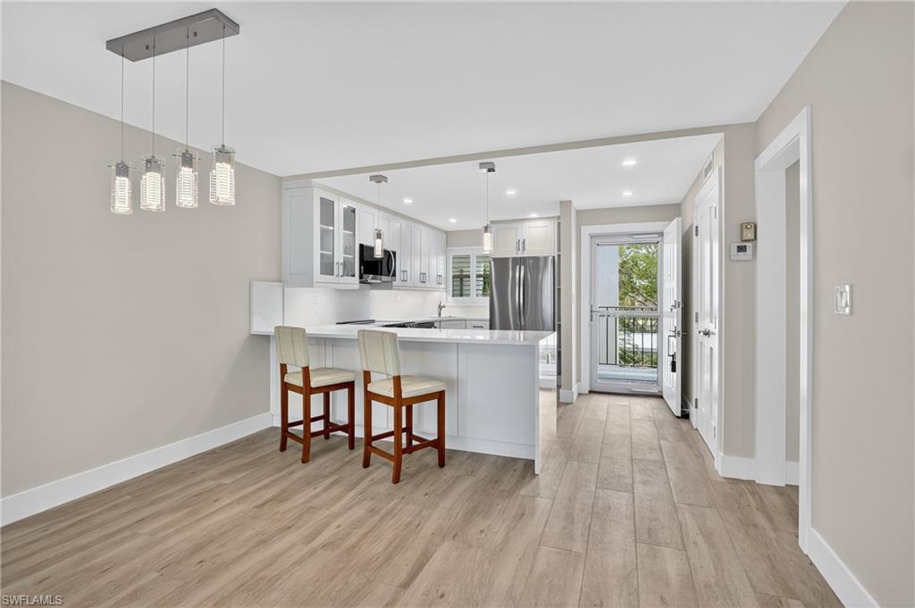 29 High Point Circle East, Unit 204 Naples, FL 34103 - Photo 8 of 29 a dining room with furniture and wooden floor