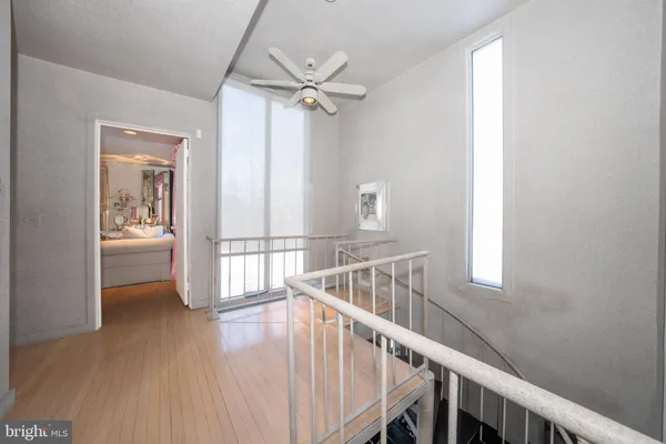 a view of a hallway with wooden floor and staircase