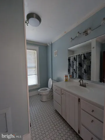 a spacious bathroom with a granite countertop sink and a mirror