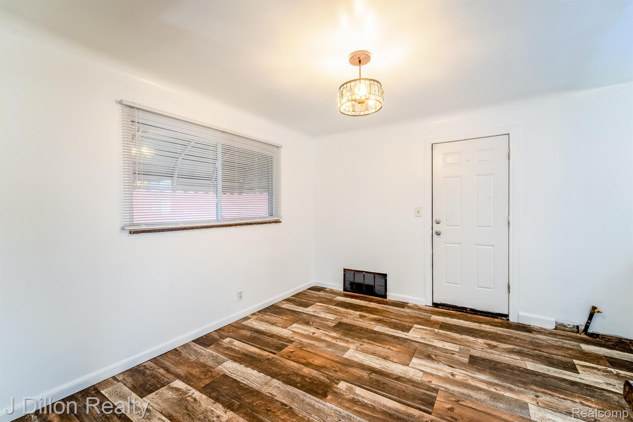 99 Chestnut Street River Rouge, MI 48218 - Photo 13 of 50 Spare room featuring suspended lighting, wood finished floors, and a fireplace